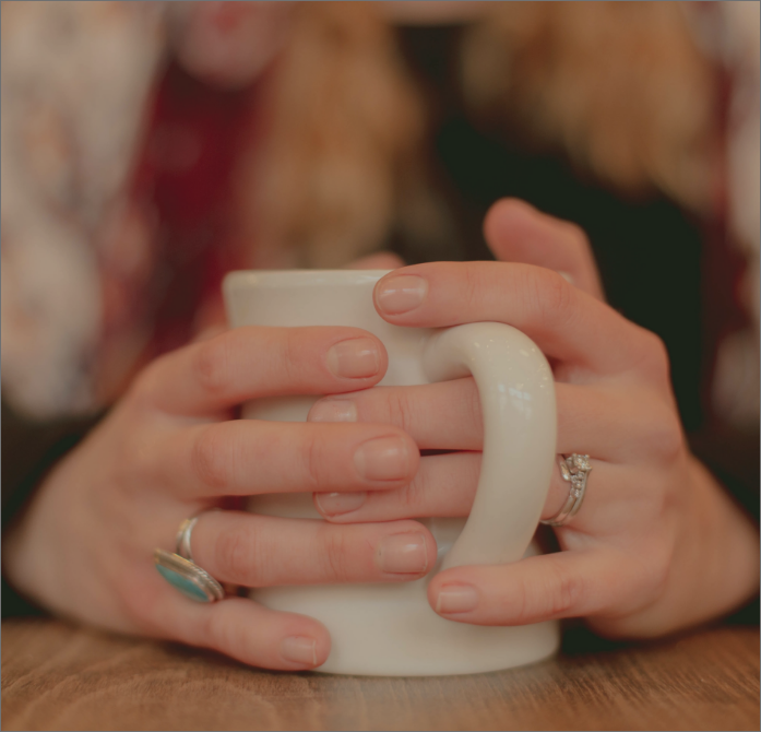 two hands wrapped around a mug